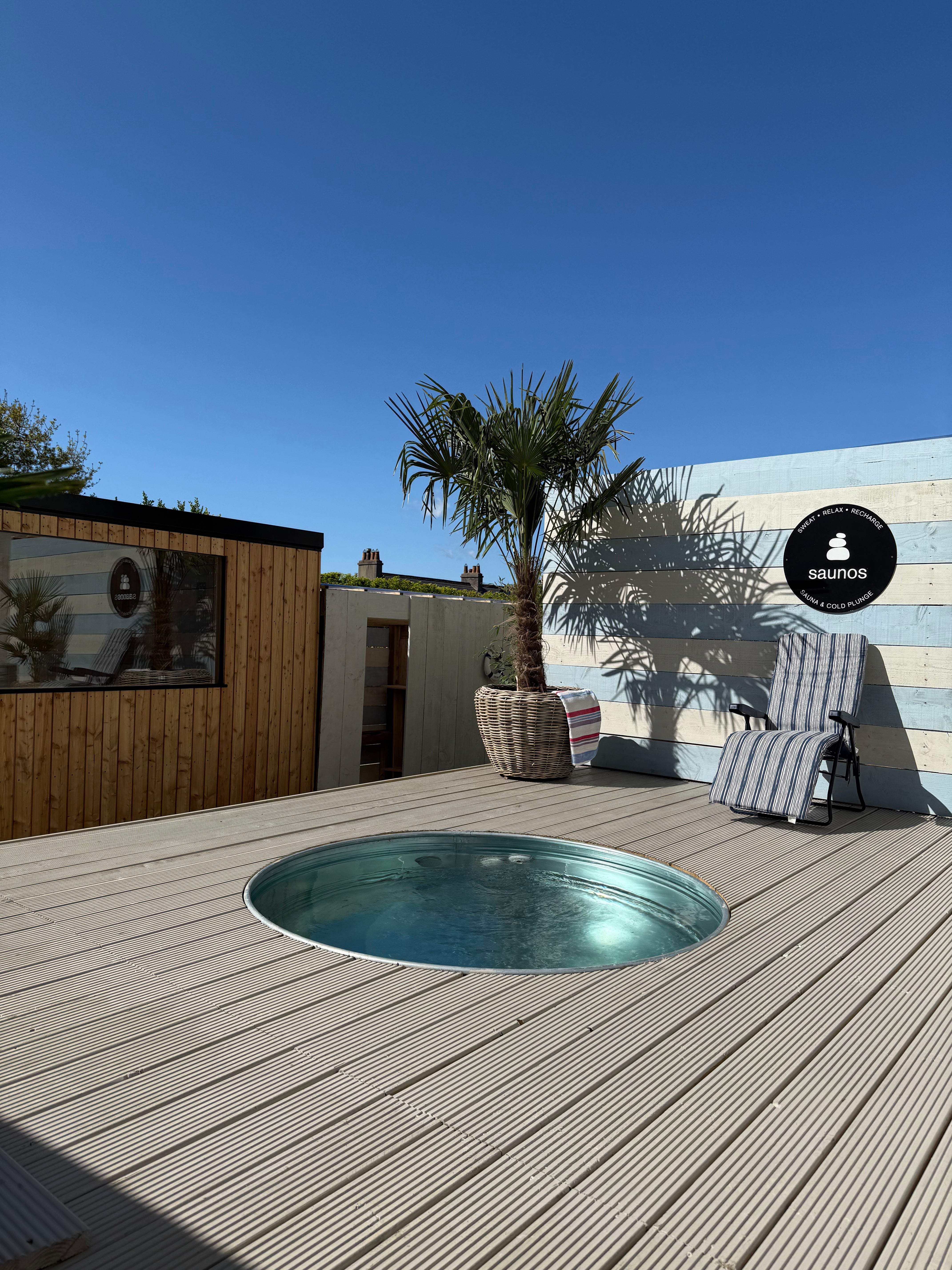 The outdoor setup combines the sauna with cold plunge tubs.