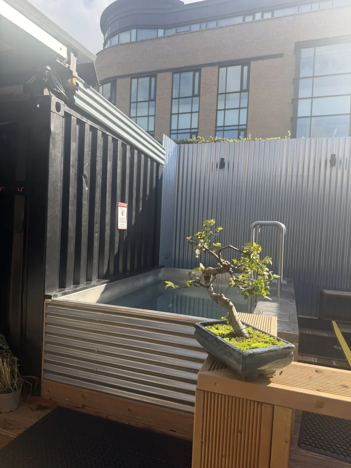 The outdoor setup combines the sauna with cold plunge tubs.